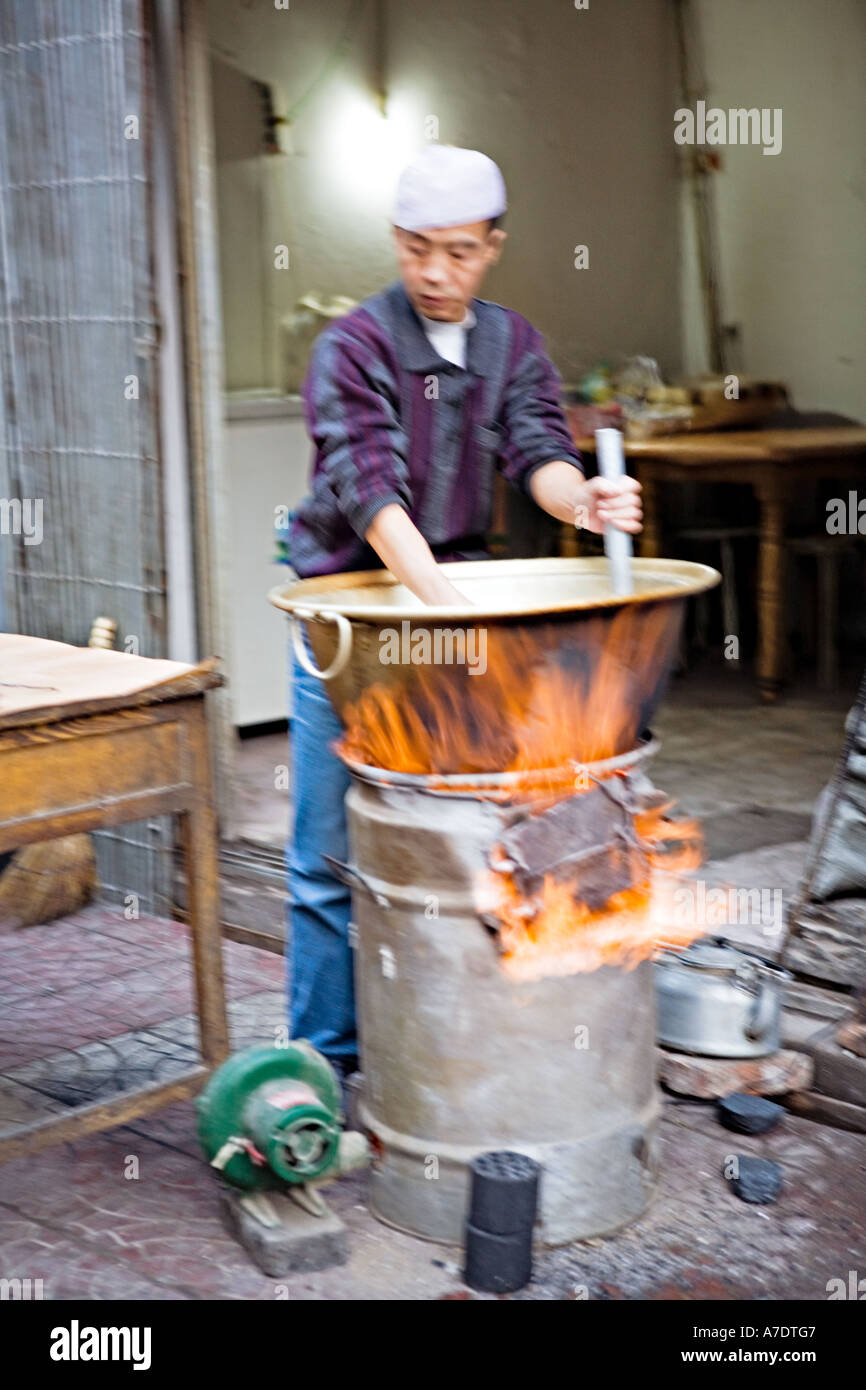 CHINA XIAN Chinese restaurant worker cooking in huge brass wok over roaring  fire on sidewalk in Muslim Quarter of old Xi an Stock Photo - Alamy