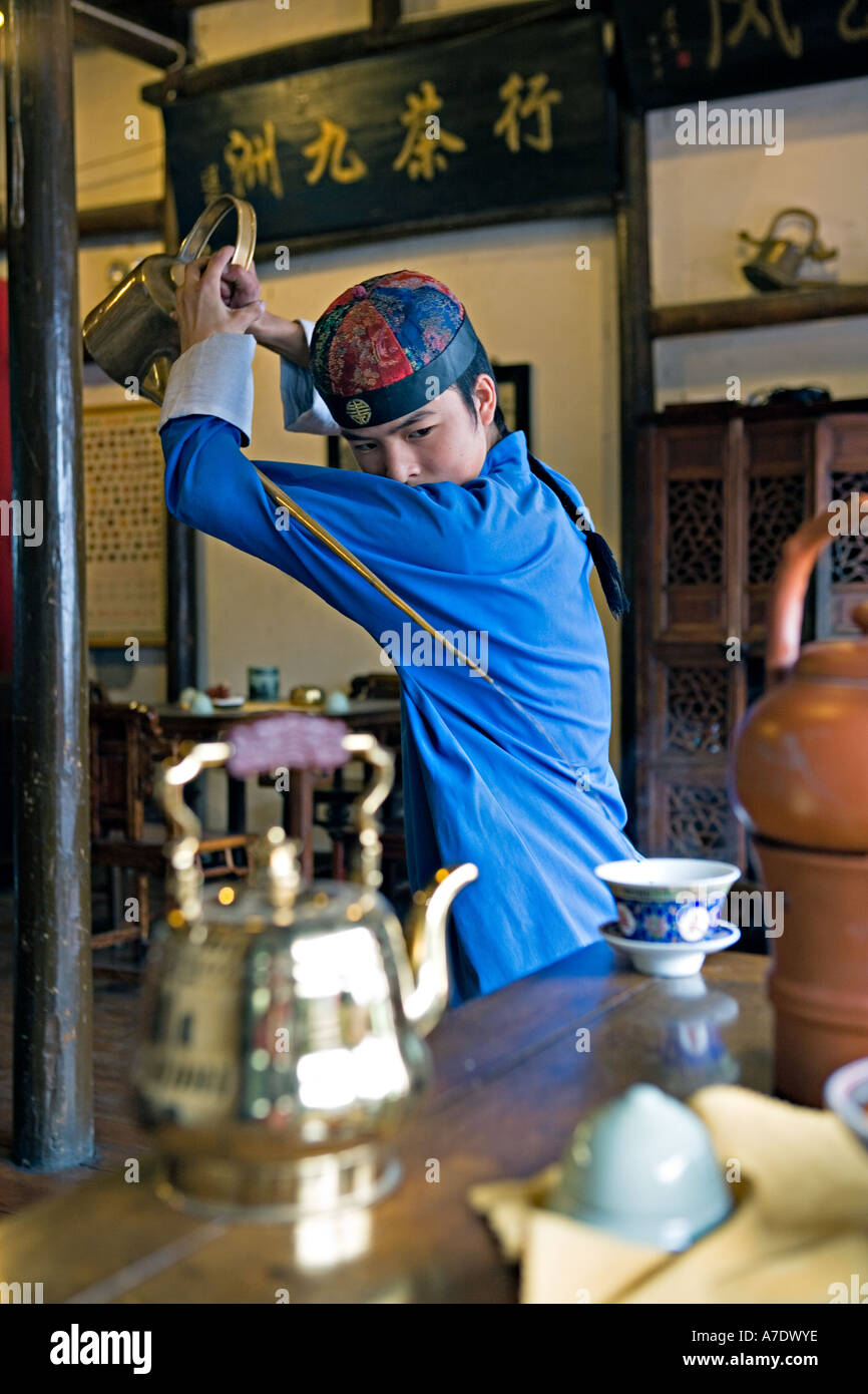 CHINA HANGZHOU Young tea server pours tea from behind his back using  antique long spout teapot Stock Photo - Alamy