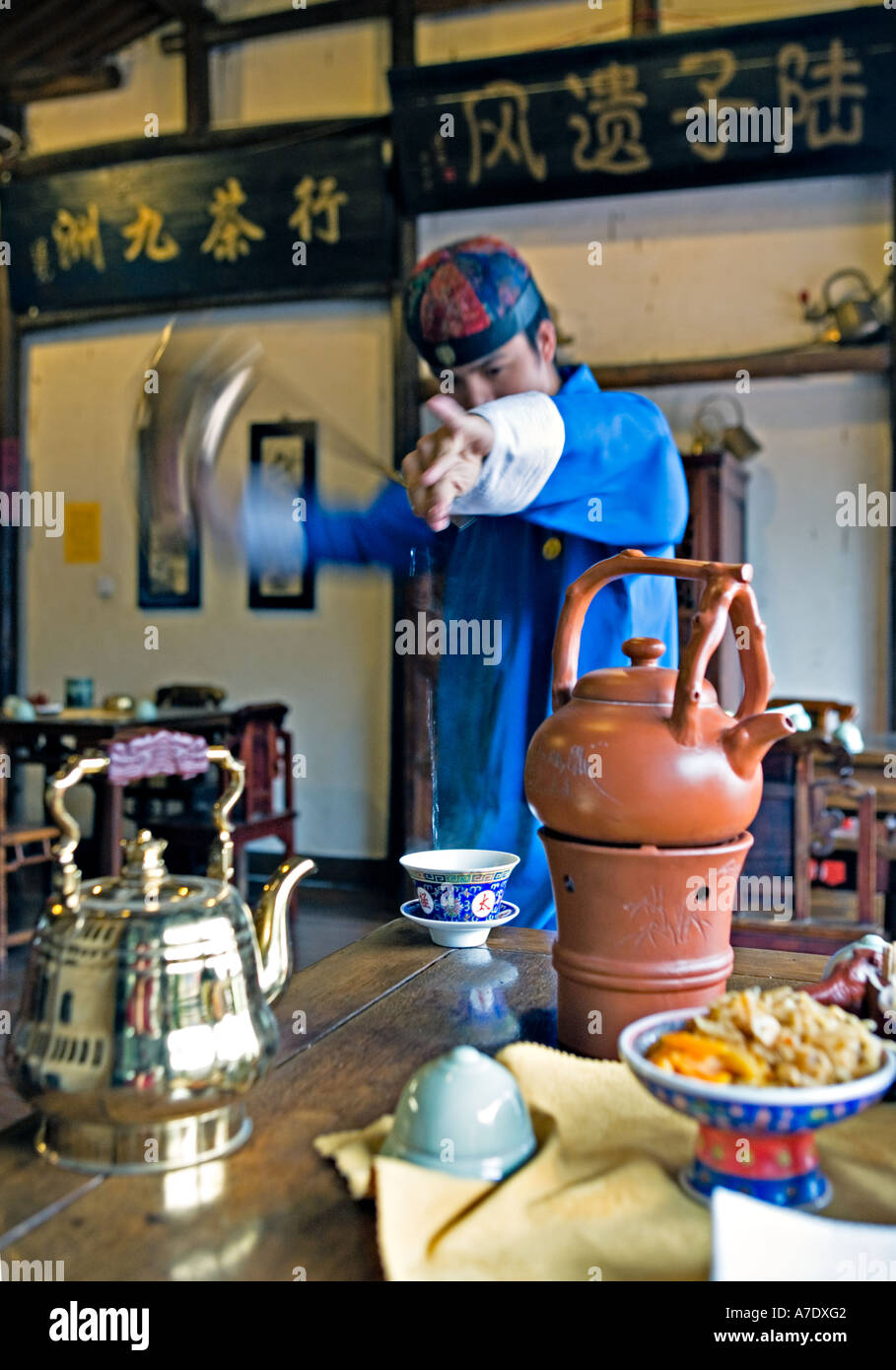 https://c8.alamy.com/comp/A7DXG2/china-hangzhou-young-tea-server-pours-tea-from-behind-his-back-using-A7DXG2.jpg