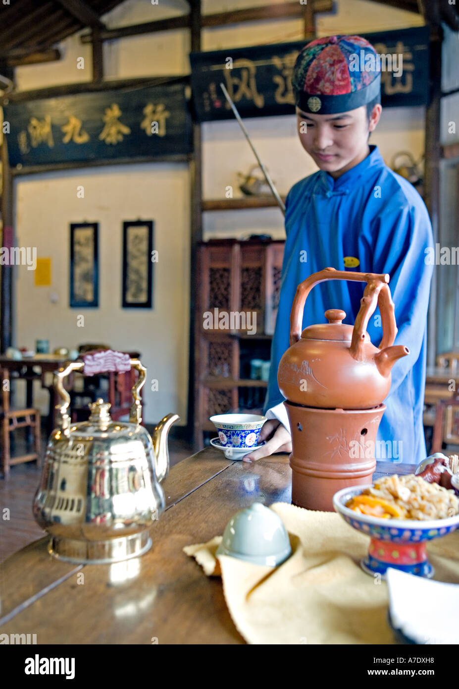 CHINA HANGZHOU Young tea server pours tea from behind his back using  antique long spout teapot Stock Photo - Alamy