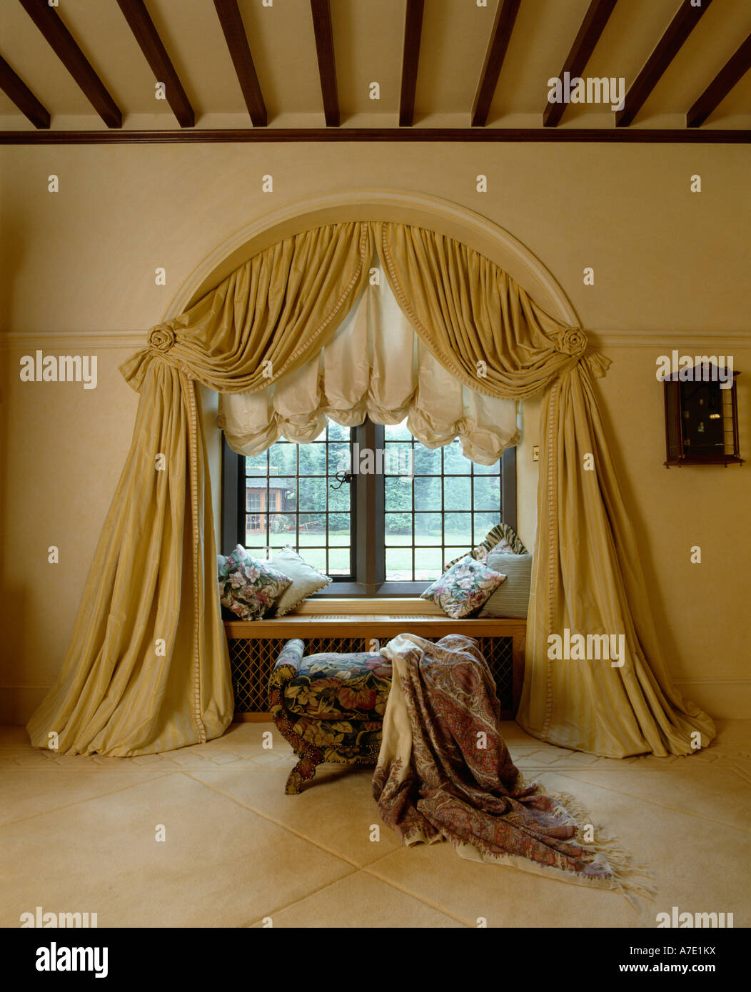 Cream festoon blind and curtains above window seat in sittingroom with