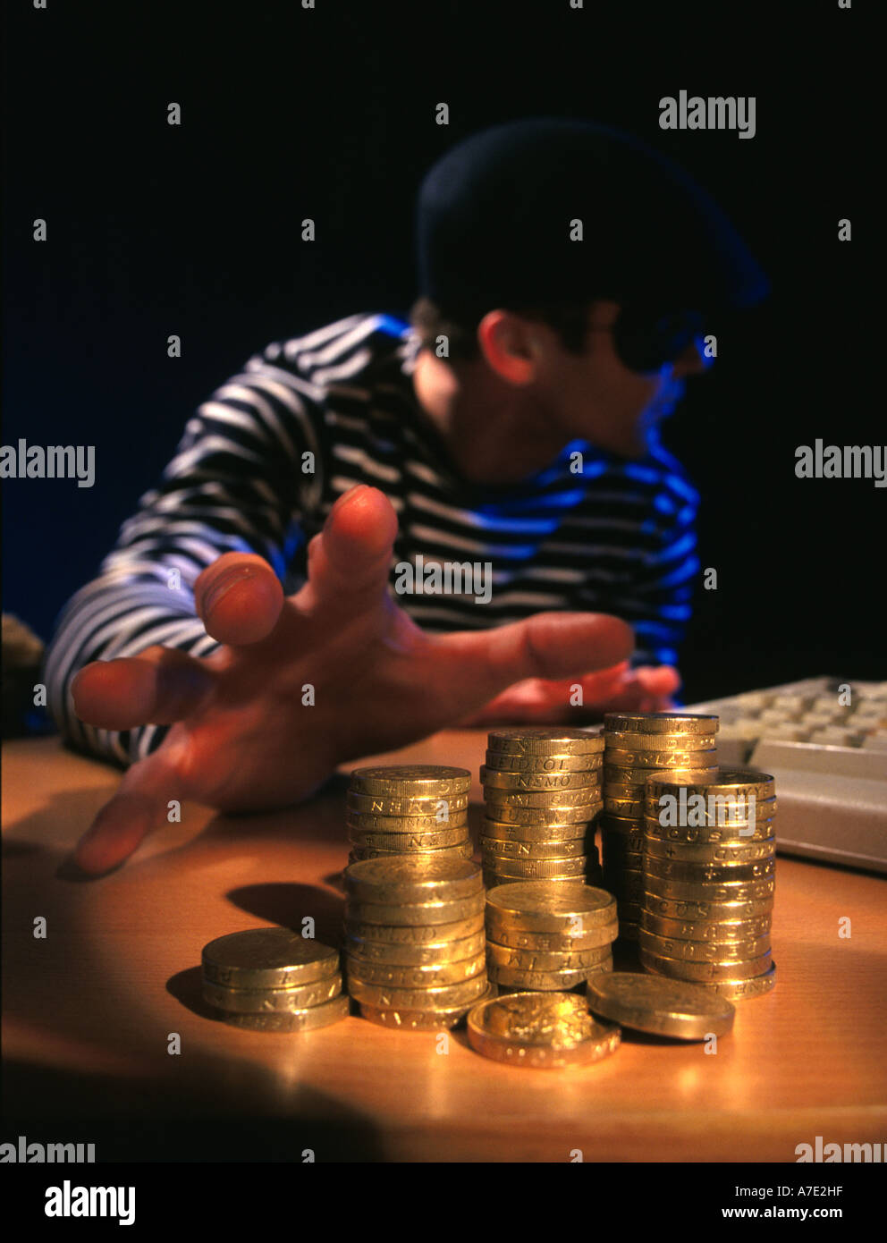 Burglar in traditional costume.Burglar stealing a pile of coins Stock Photo
