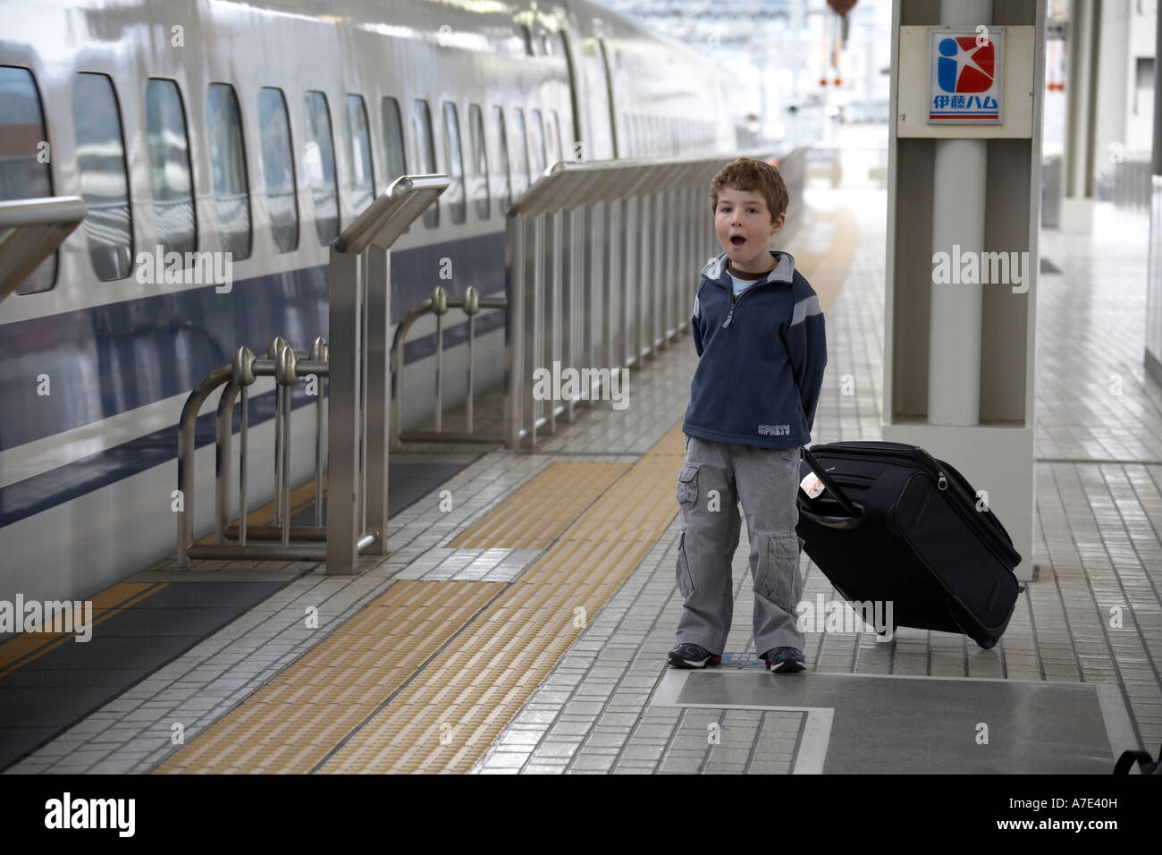 Young boy with luggage looking at Japan Railways Shinkansen Super