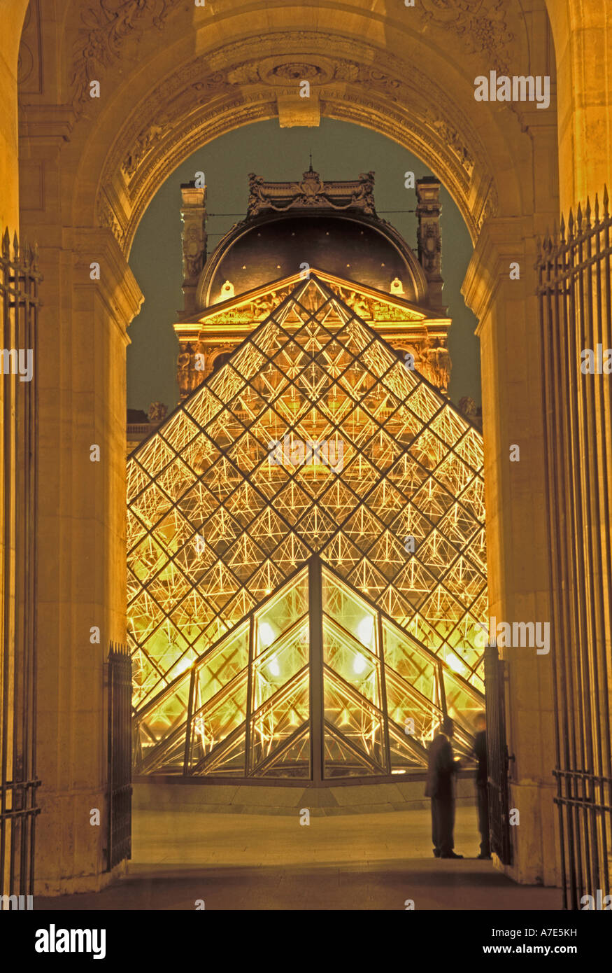 Europe France Paris P M Pei's Louvre pyramid seen through an arch in the Louvre at night Stock Photo
