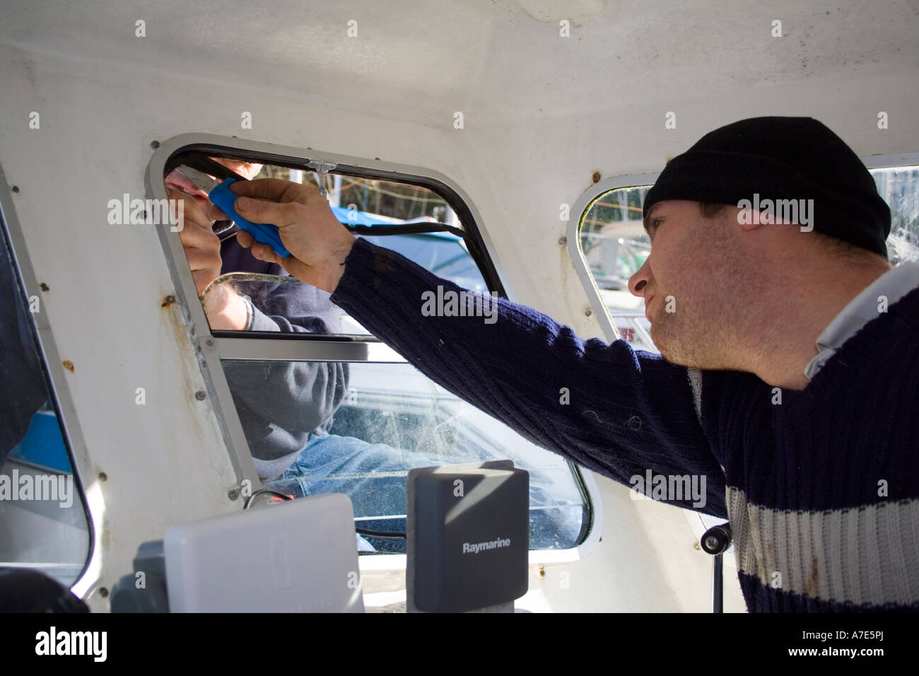 A Fisherman repairs his boat Stock Photo Alamy