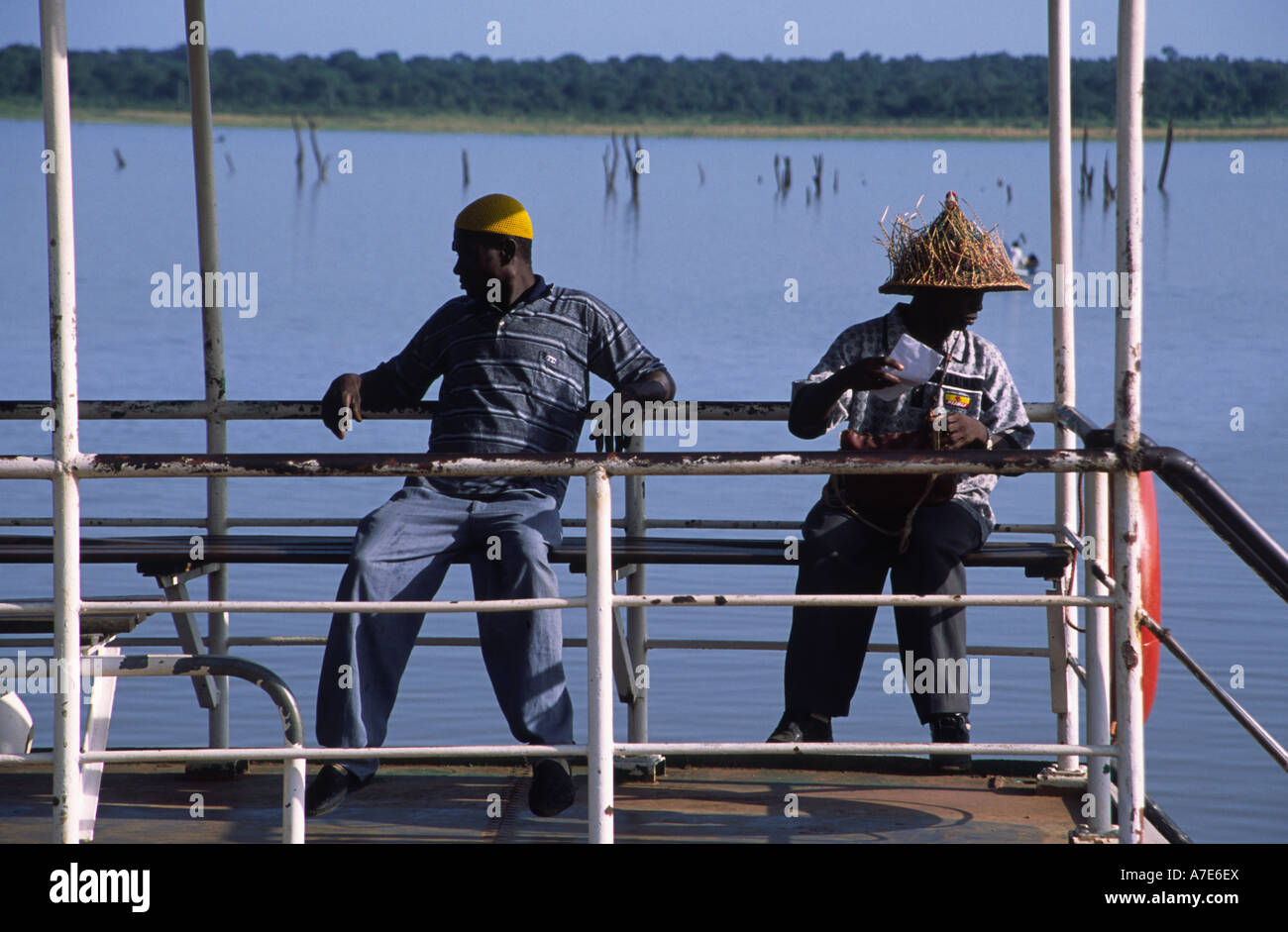 Two men at the ferry port of dumbai wait for the ferry to depart and take them across lake Volta.  Ghana, West Africa Stock Photo