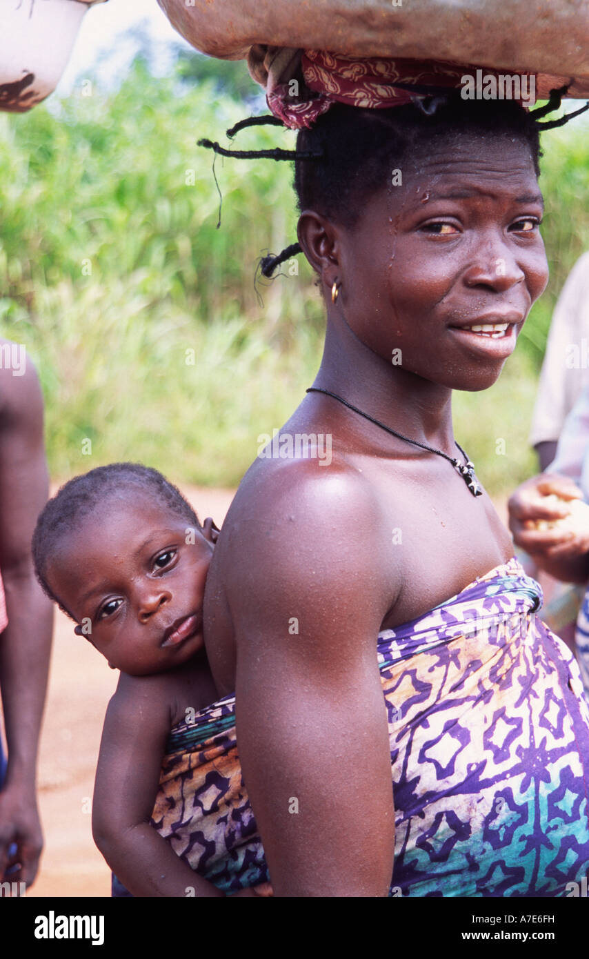 African woman carrying baby on her back. Volta region, Ghana, West Africa Stock Photo