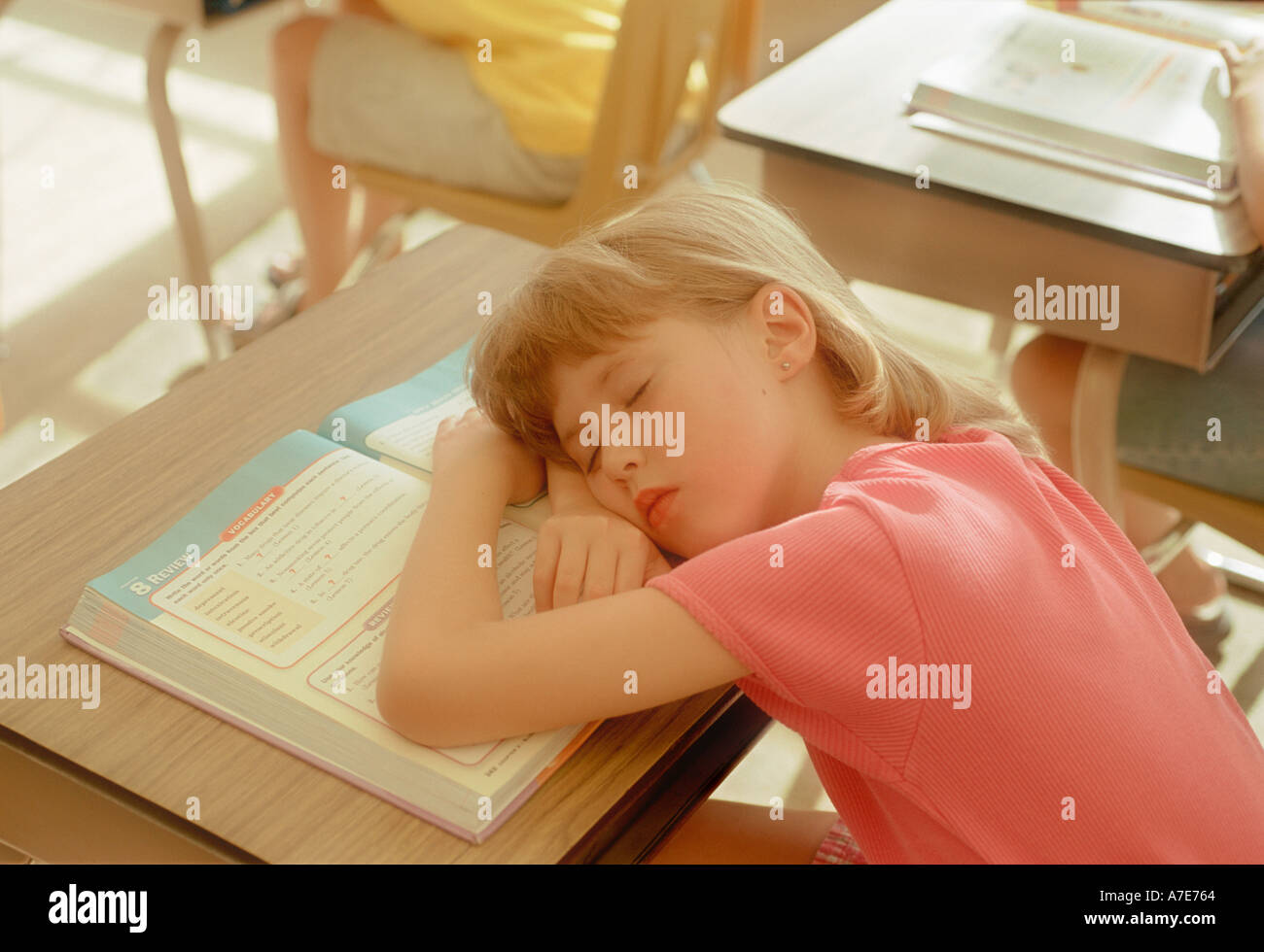 Girl sleeping in school classroom Stock Photo