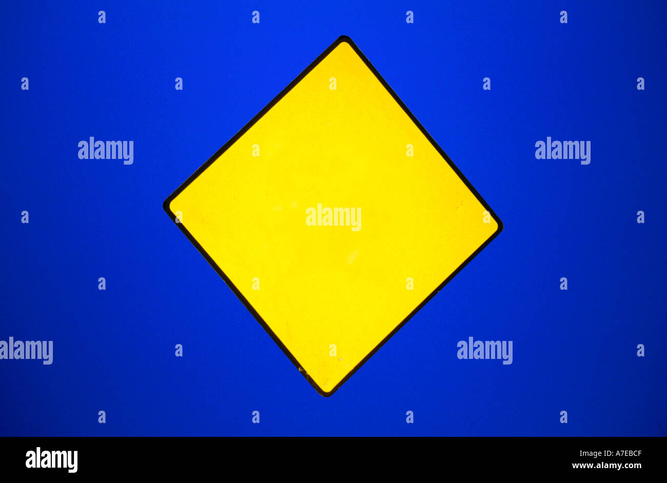 Yellow diamond road sign blank on blue background Landscape format Stock Photo