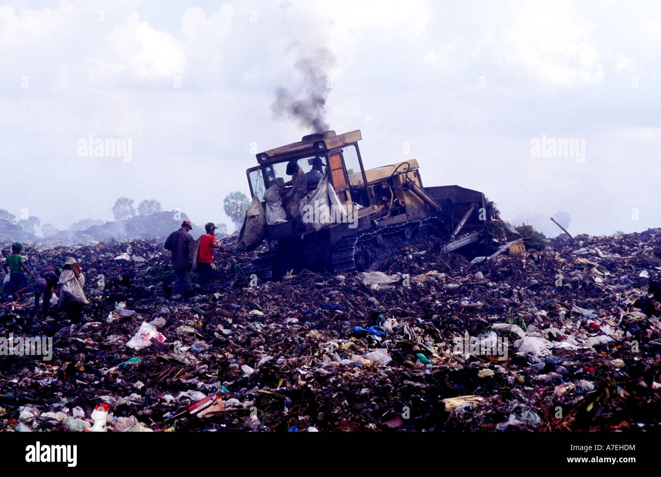 A bulldozer ploughs through trash at Phnom Penh s Steung Meanchey rubbish dump Stock Photo