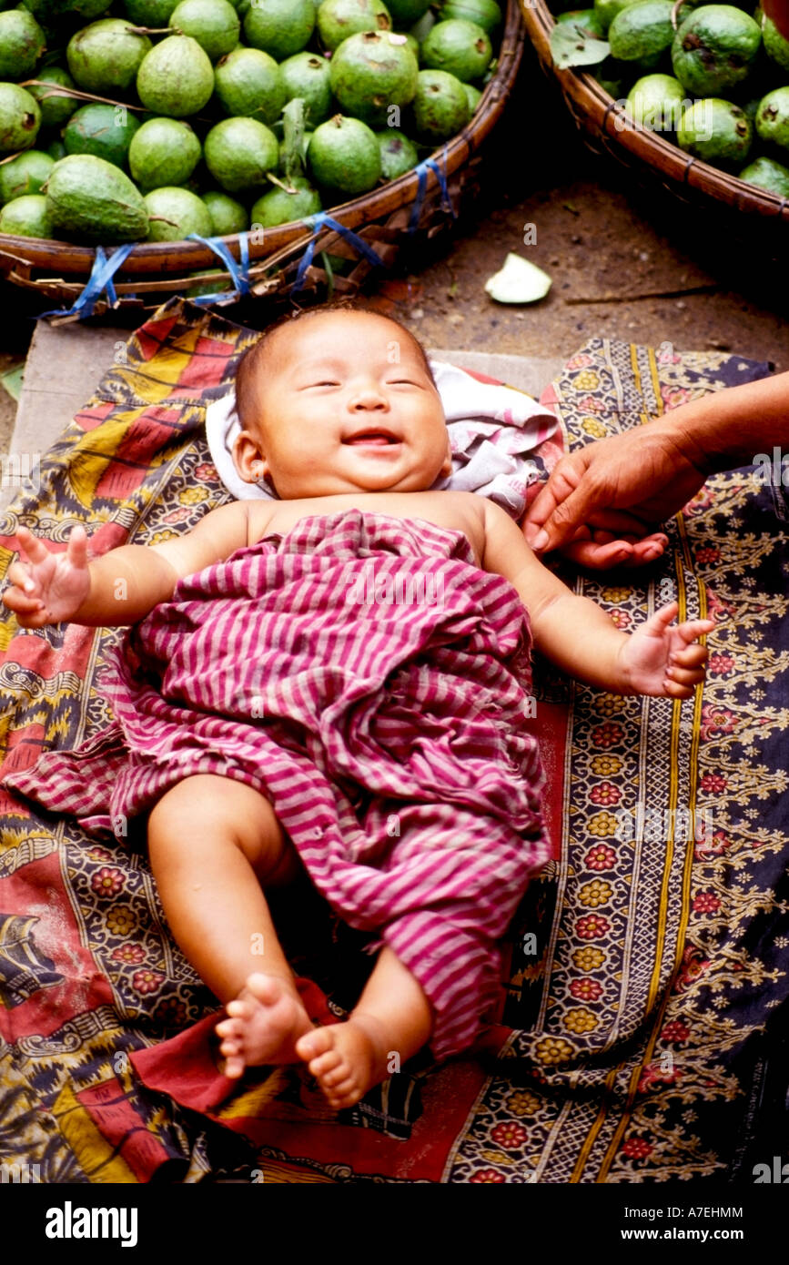 Smiling baby wrapped ina traditional Khmer scarf krama at a street market in Phnom Penh Stock Photo