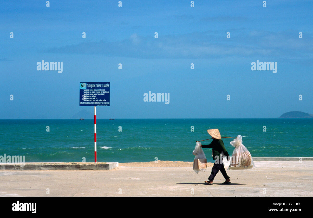 Feb 08, 2003 - Beach vendor transporting goods on his shoulders along the shore of the South China Sea Stock Photo