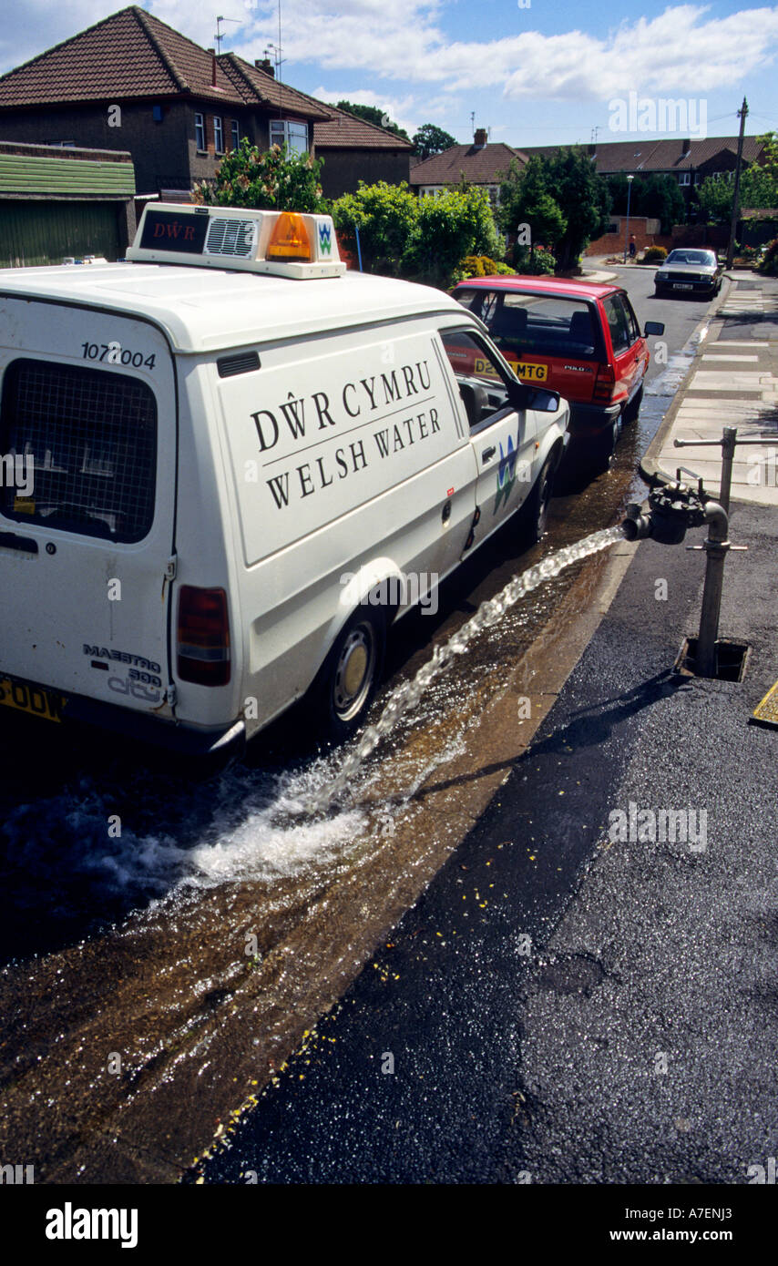 Welsh Water van beside standpipe directing water to waste in street gutter in residential area Cardiff Wales UK Stock Photo