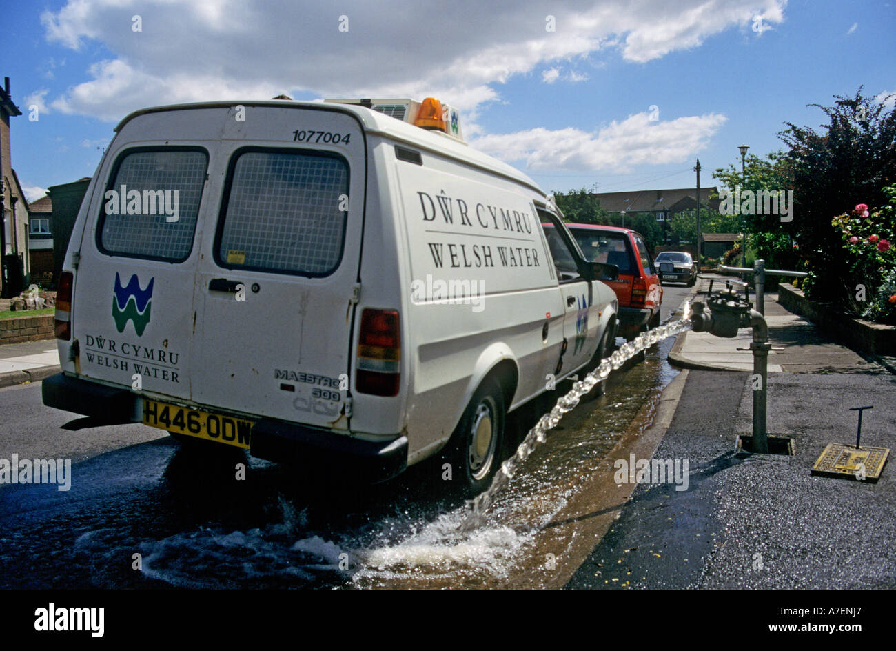 Welsh Water van beside standpipe directing water to waste in street gutter in residential area Cardiff Wales UK Stock Photo