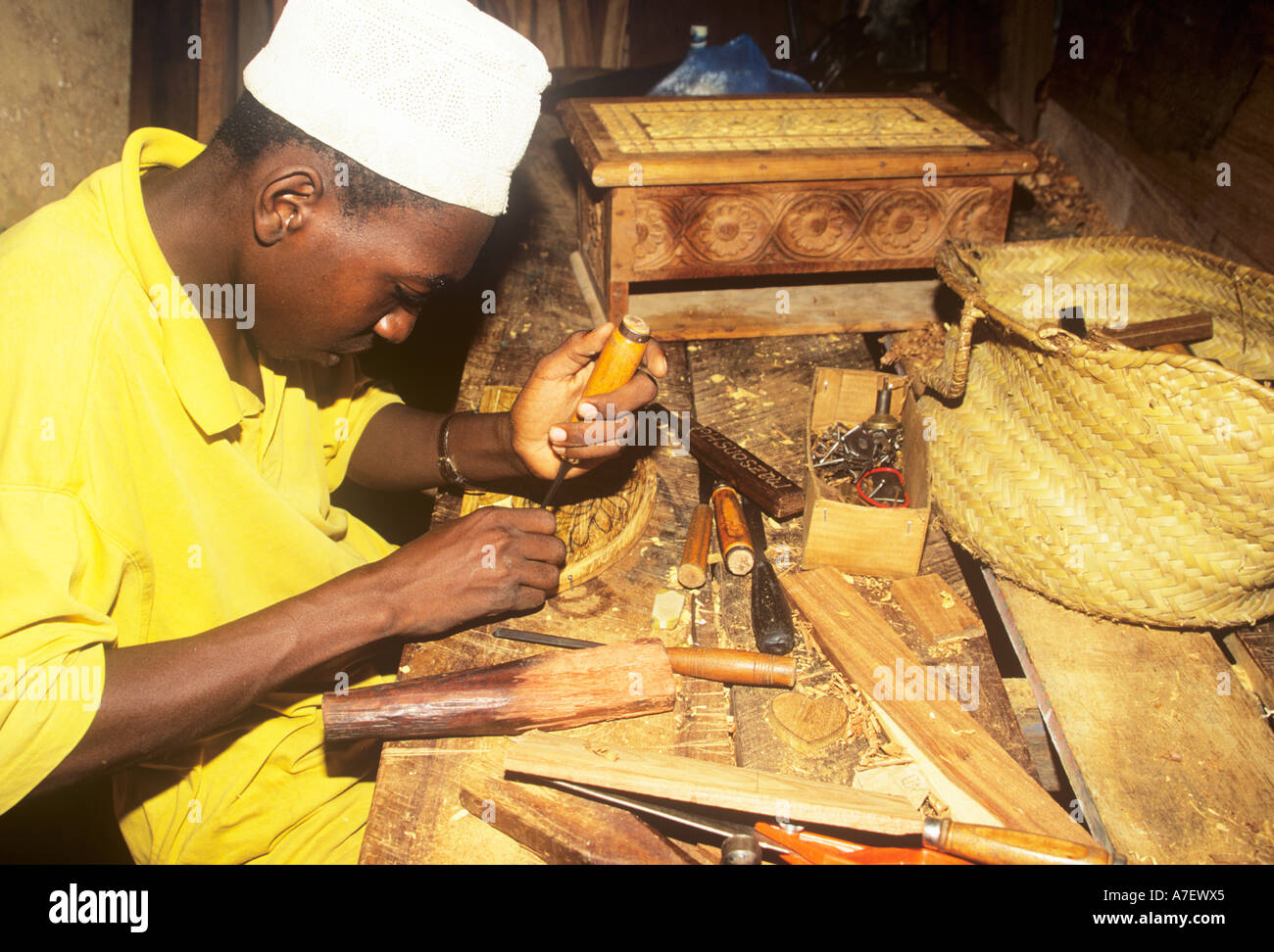 Zanzibari craftsman carving wood Stock Photo Alamy