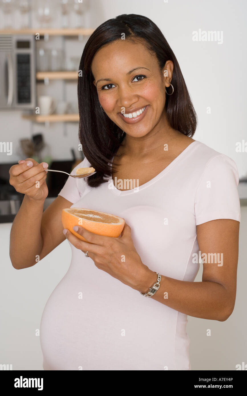 Pregnant African woman eating grapefruit Stock Photo Alamy