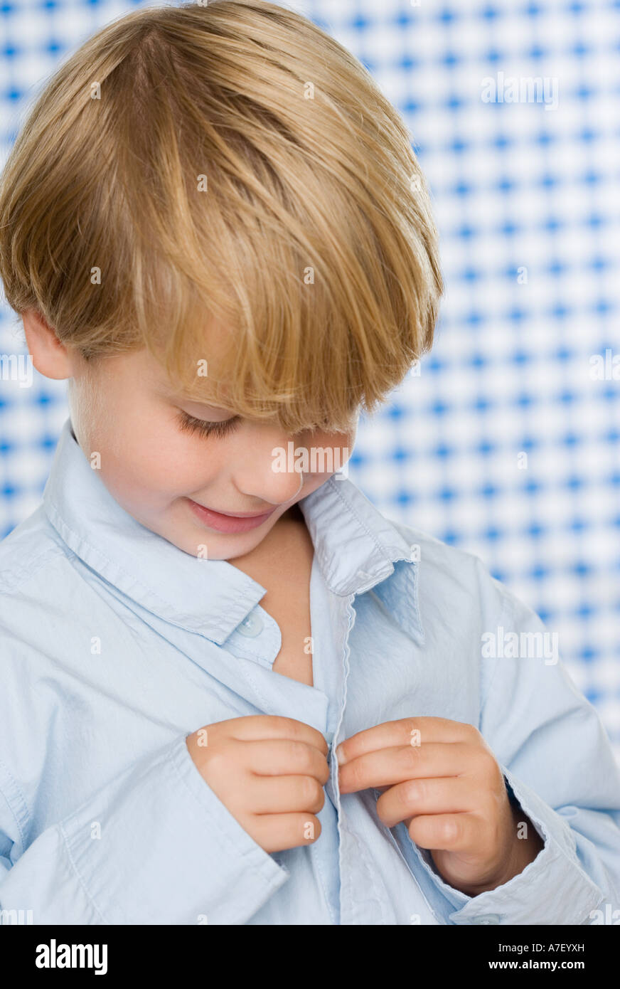 Young boy buttoning shirt Stock Photo Alamy