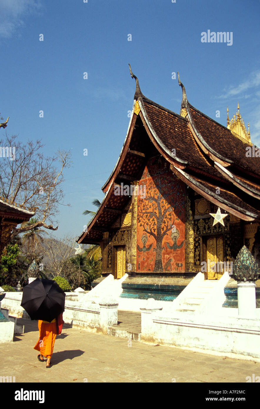 Monk walking  through Wat Xieng Thong, Luang Prabang, Laos Stock Photo