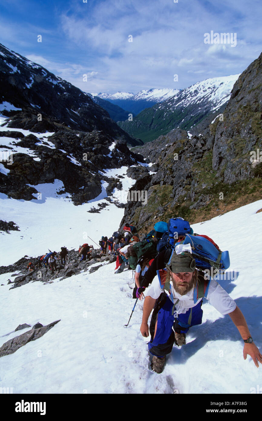 USA Alaska Line of hikers climb snow covered slope to summit of Chilkoot Pass during Dyea to Dawson Race Stock Photo