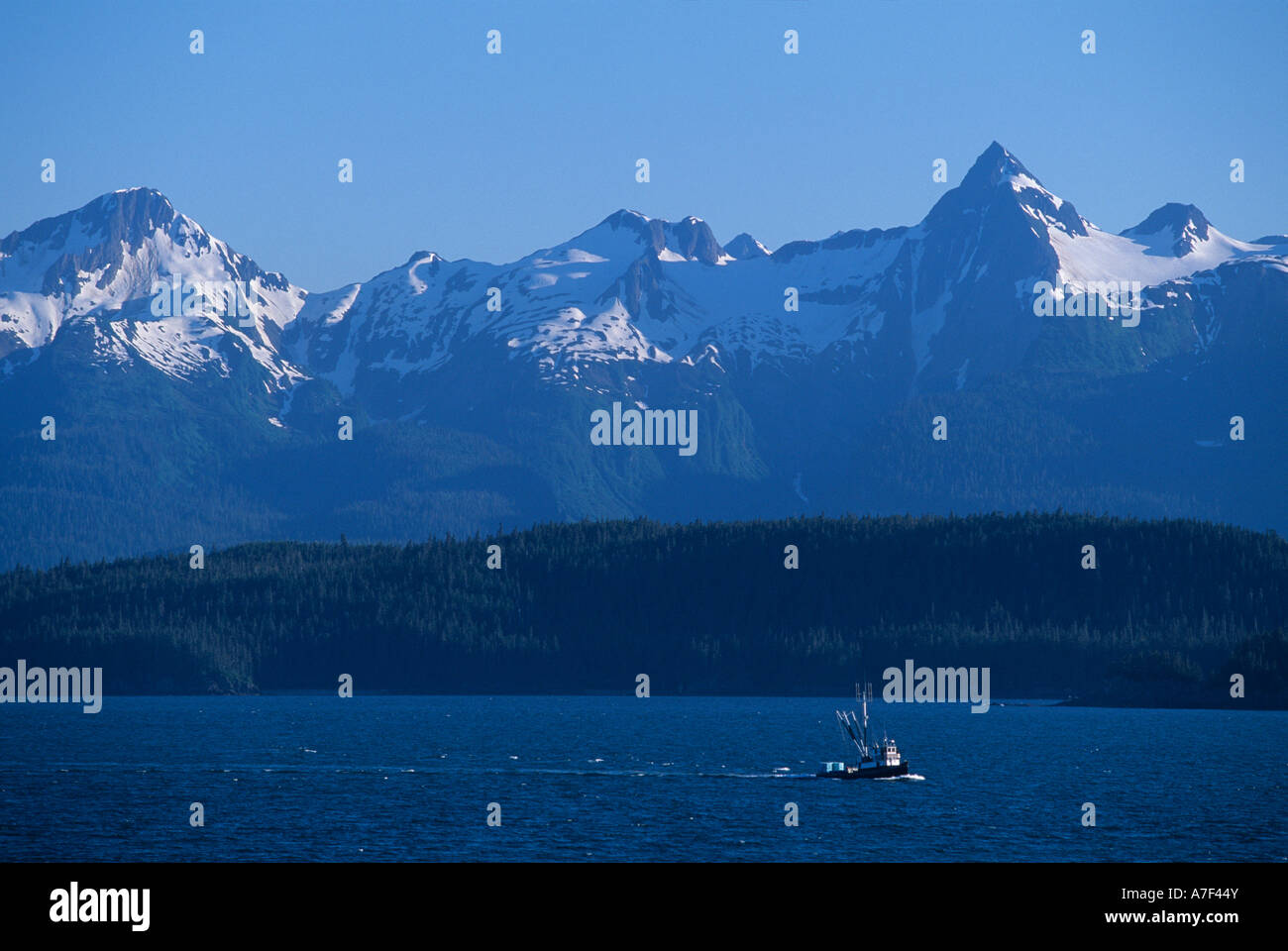 USA Alaska Fishing boat sails along Inside Passage in summer sunshine ...