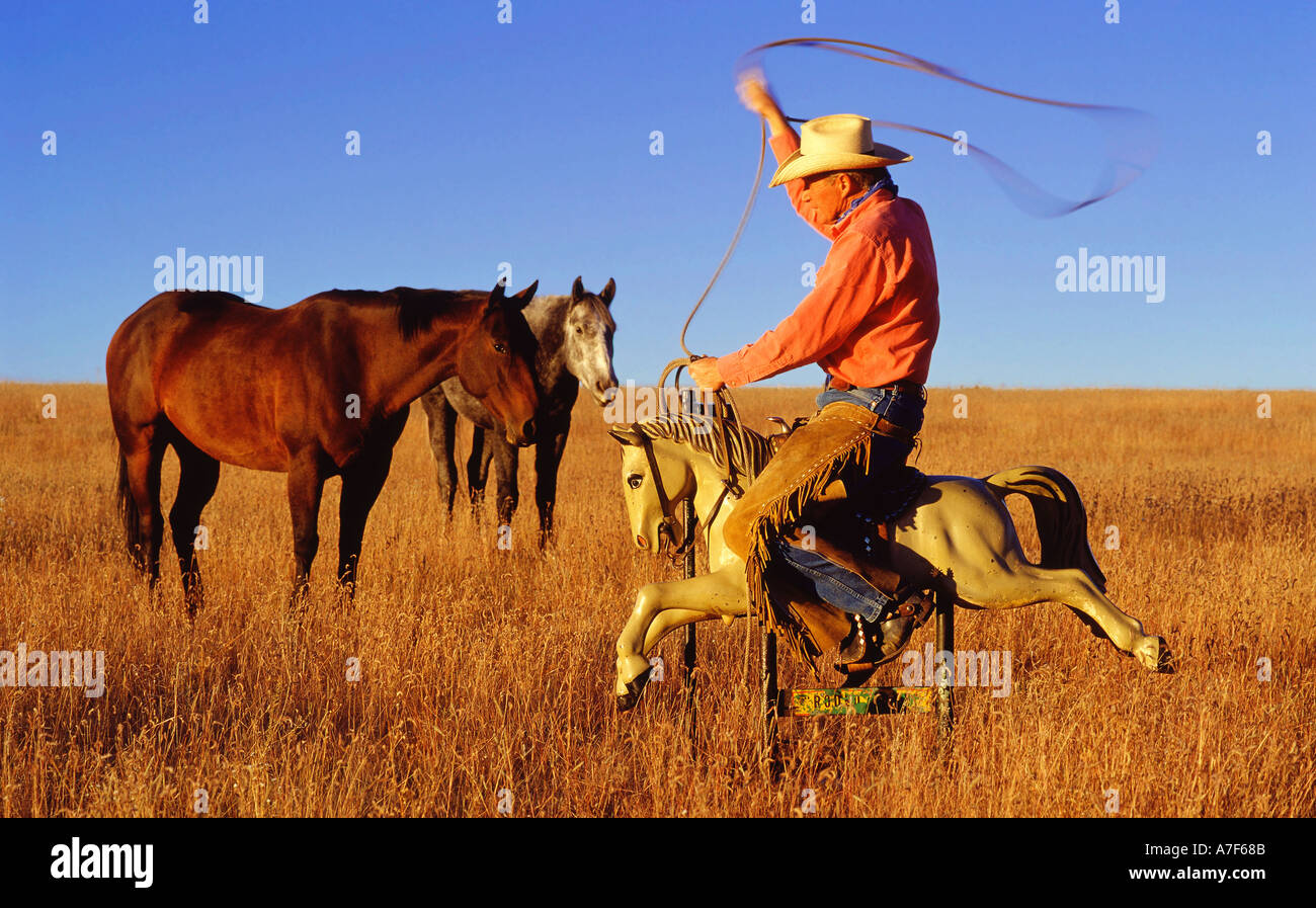 Cowboy riding an electric horse amusement ride made for children Stock Photo