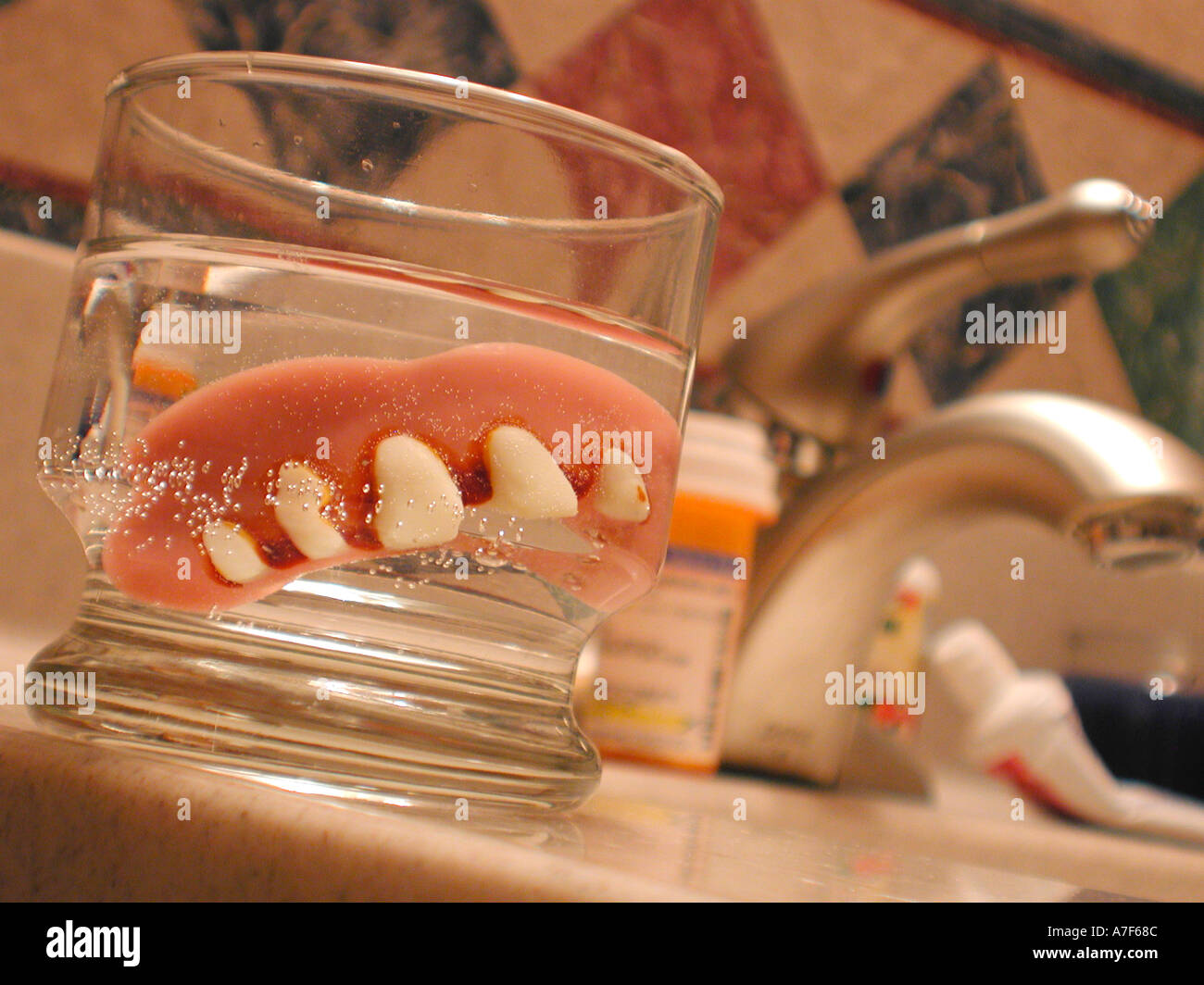 False teeth soak in bathroom glass Stock Photo Alamy