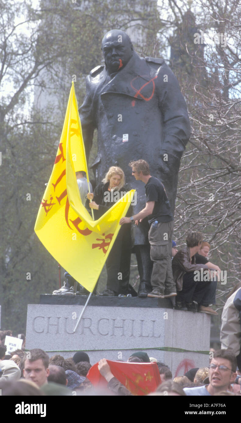 Protesters stand on vandalised and spray painted Winston Churchill statue at Mayday anti globalisation protest Parliment Square  Stock Photo