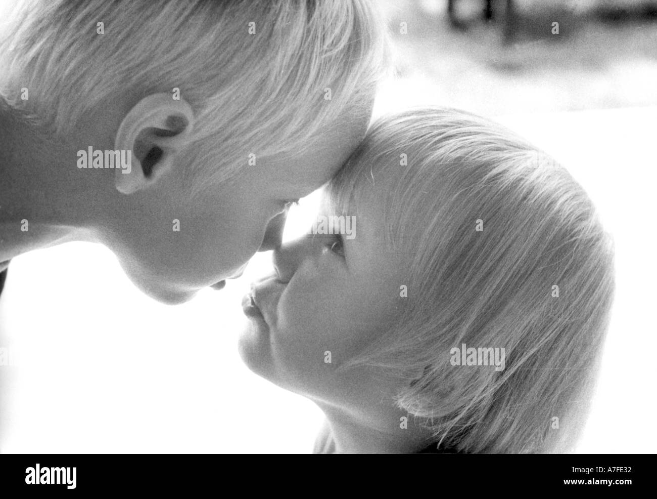 Three year old girl and her four year old brother touching noses Stock Photo