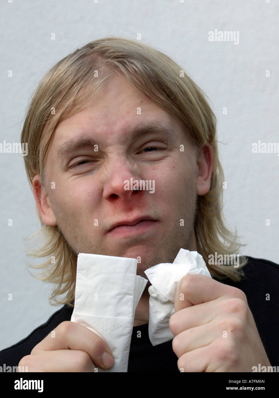 MR young man catching a cold getting the sniffels having a red nose