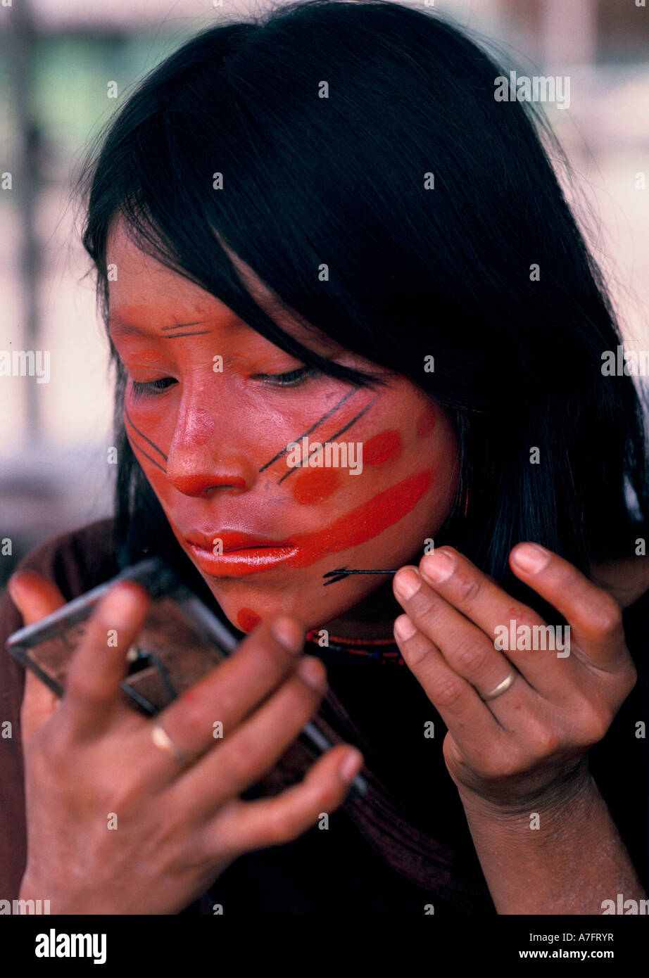 Amazon Rainforest Brazil: Ashaninka Indian girl applies the finishing