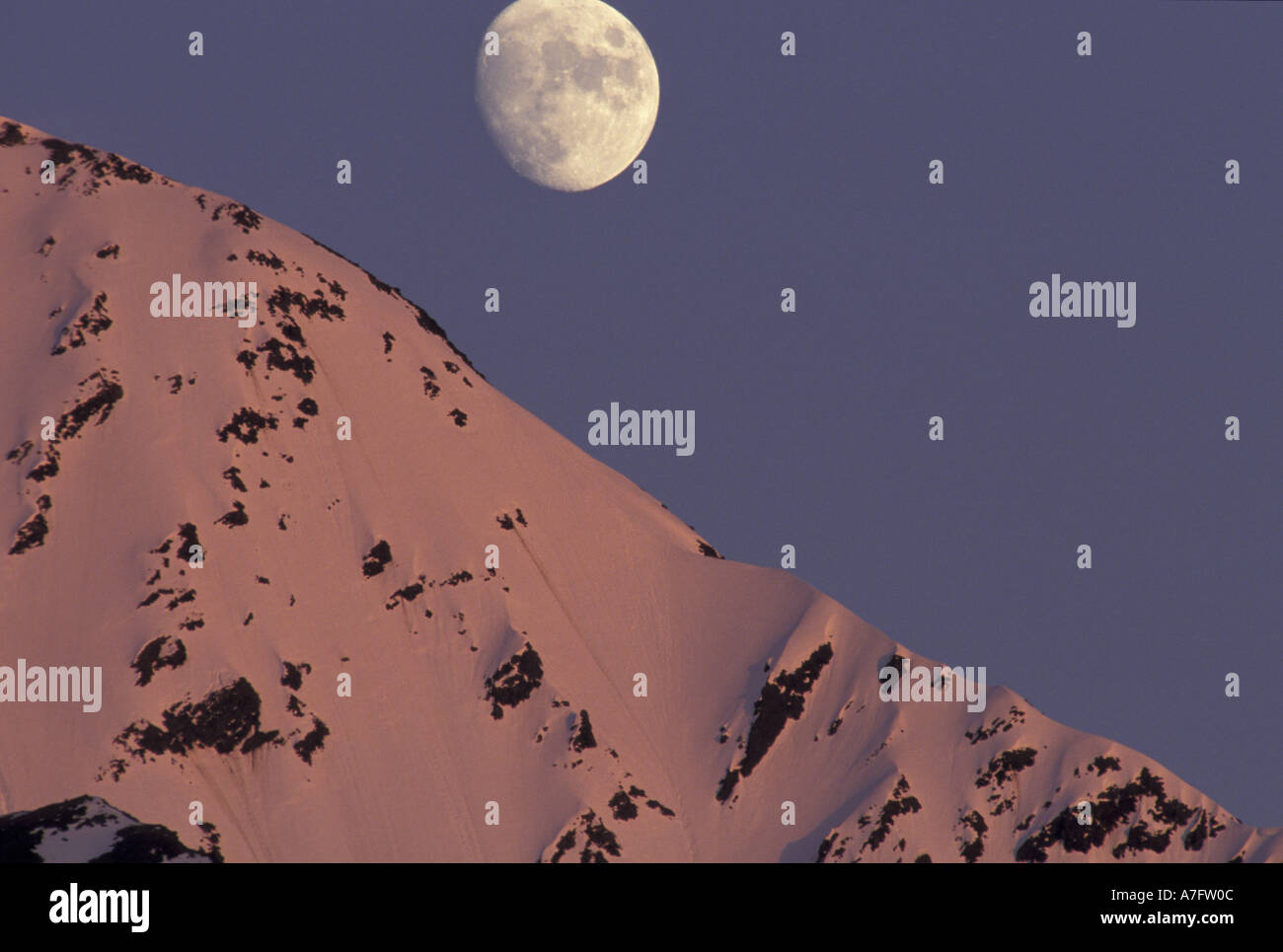 Alaska, Turnagain Arm Moon rises over snow-covered Kenai Mountains Stock Photo