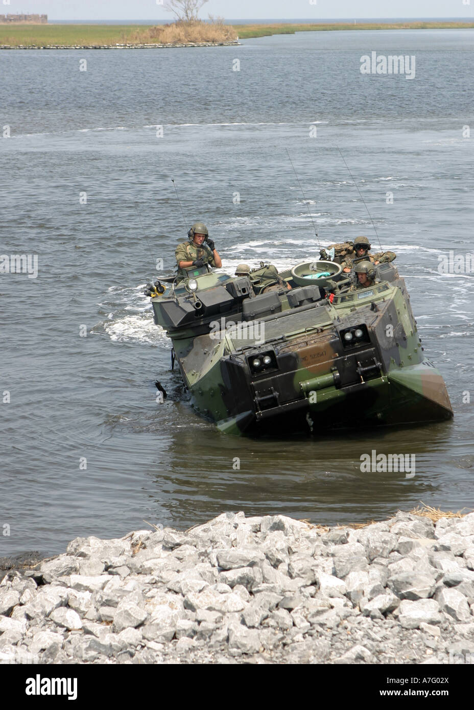 An amphibious assault vehicle climbs out of water as it arrives at a remote community to conduct search and rescue operations. Stock Photo