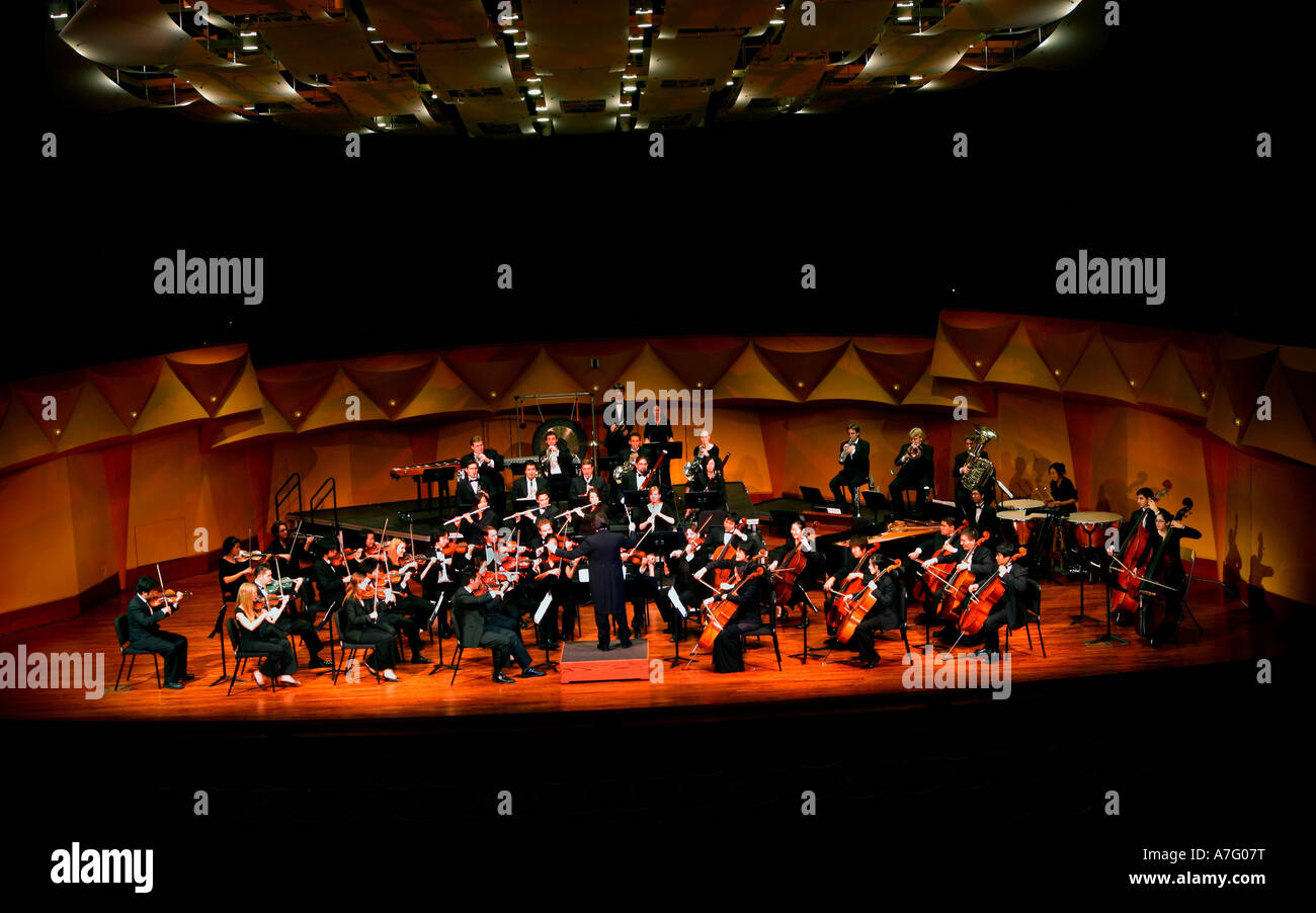 Music Director Kimo Furumoto directs student musicians or the California State University Fullerton Orchestra in a concert Stock Photo