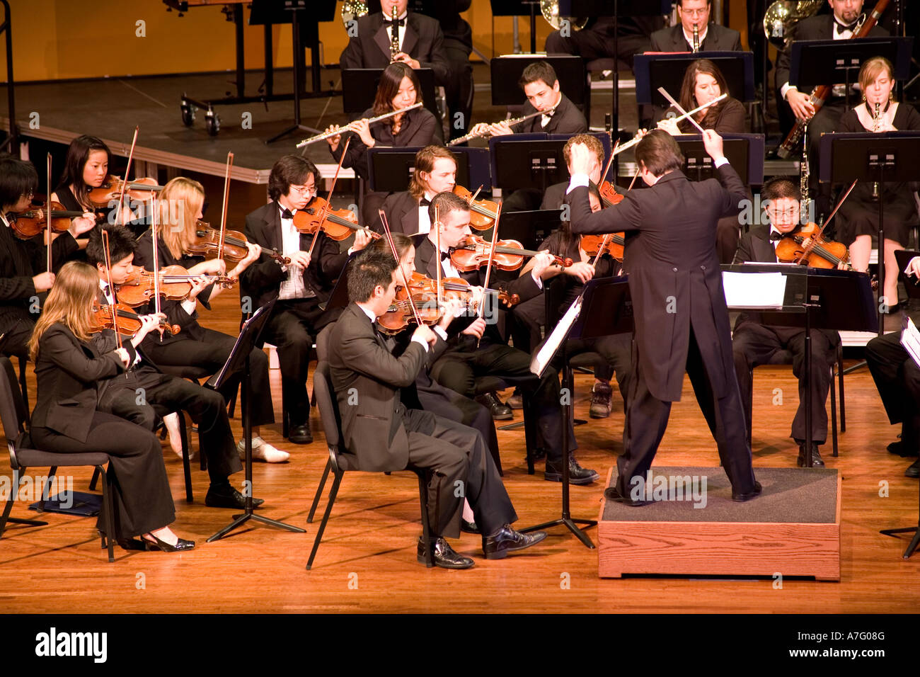 Music Director Kimo Furumoto directs student musicians or the California State University Fullerton Orchestra in a concert Stock Photo