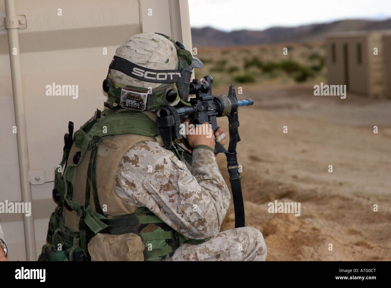 An infantry scout sights-in around the corner of a building at the ...