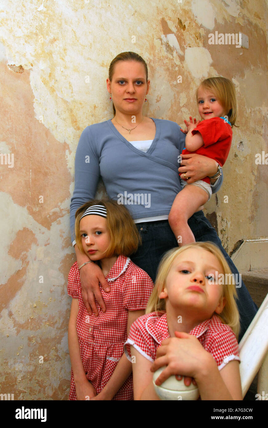 Mother with her daughters in housing in need of repair, west London, UK. Stock Photo