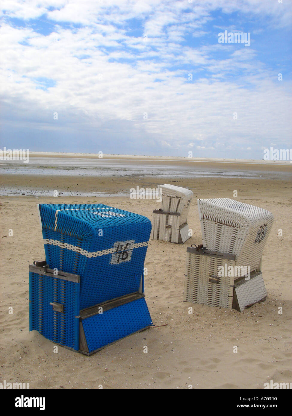 Menschenleerer Strand und drei Strandkoerbe deserted beach and three beach chairs Stock Photo