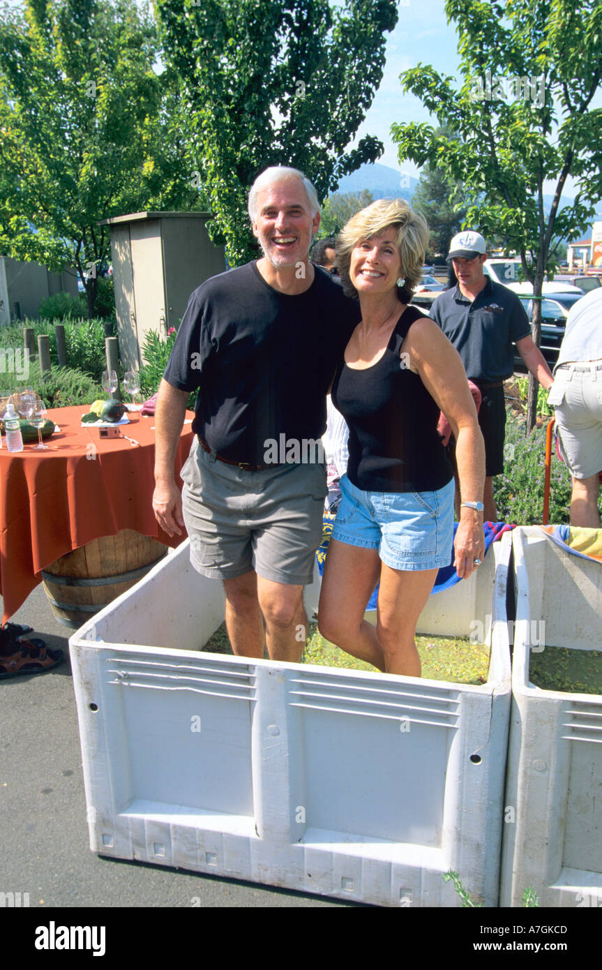 USA, California, Napa Valley, Brad and Cheri Leggett stomping grapes in