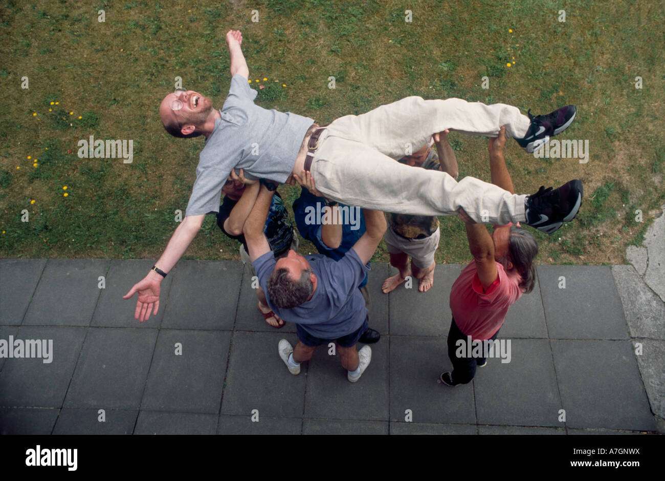 Team teamwork lift man above heads hires stock photography and images