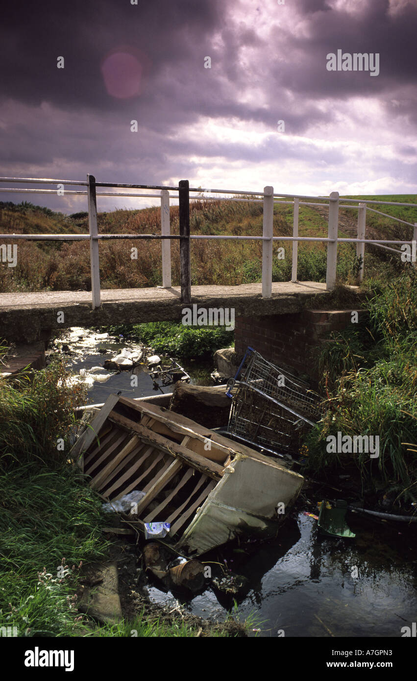 rubbish dumped in stream flowing through wasteground leeds yorkshire uk