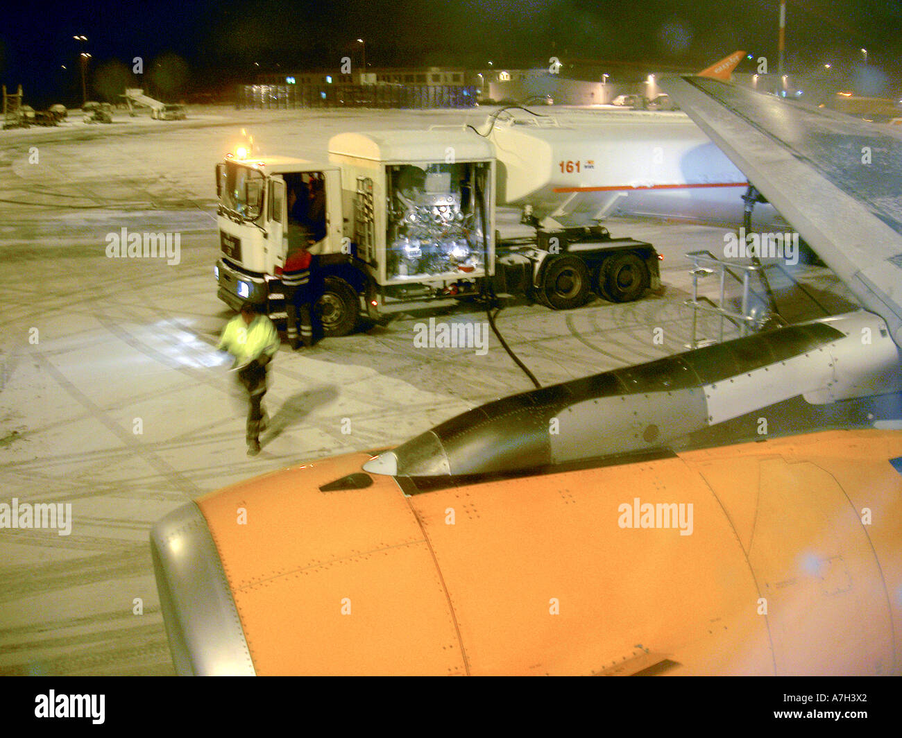 De-icing de icing melting ice from wing of passenger jet airline plane aircraft on airport apron in winter prior to take off Stock Photo