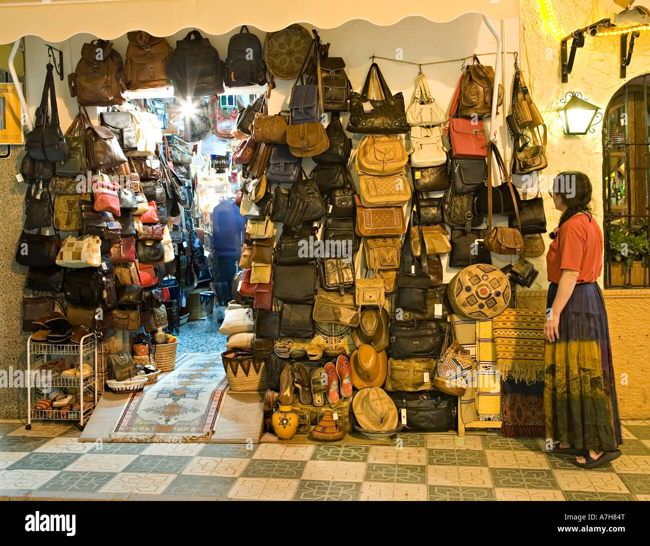 Woman tourist looking at handbags and leather goods on sale outside shop in  evening Nerja Spain Stock Photo - Alamy