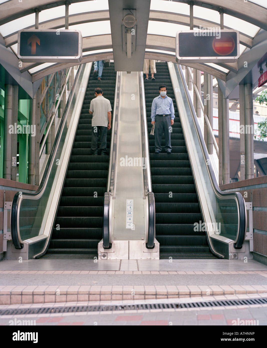 People in Hong Kong move up and down escalators in the Central District Stock Photo
