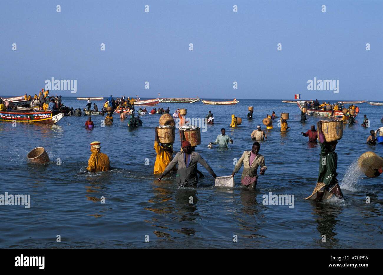 Fish market on the beach with pirogues coming in with fresh fish Petit Côte Mbour Senegal Stock Photo