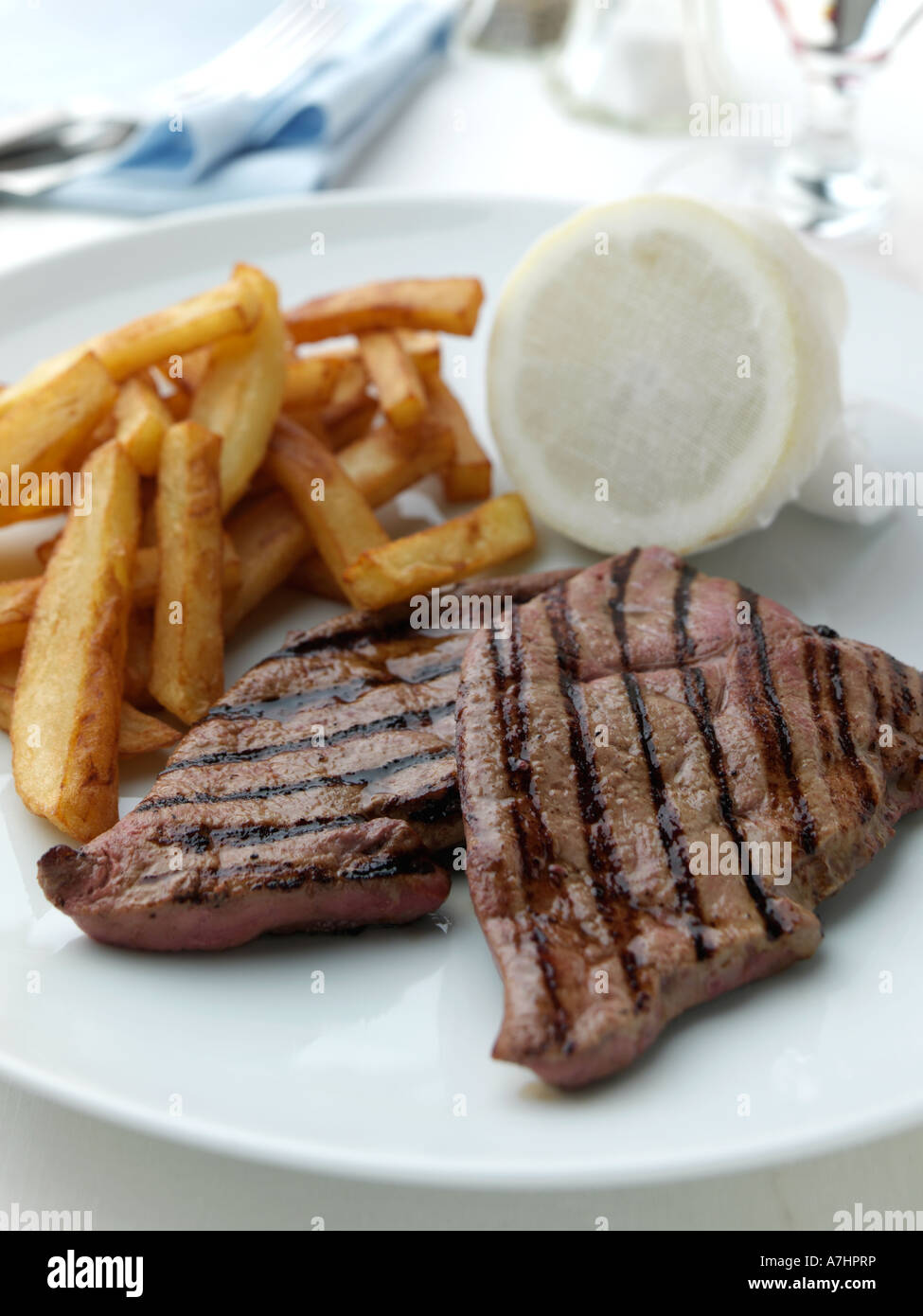 A plate of calves liver and chips in a table setting editorial food Stock Photo Alamy