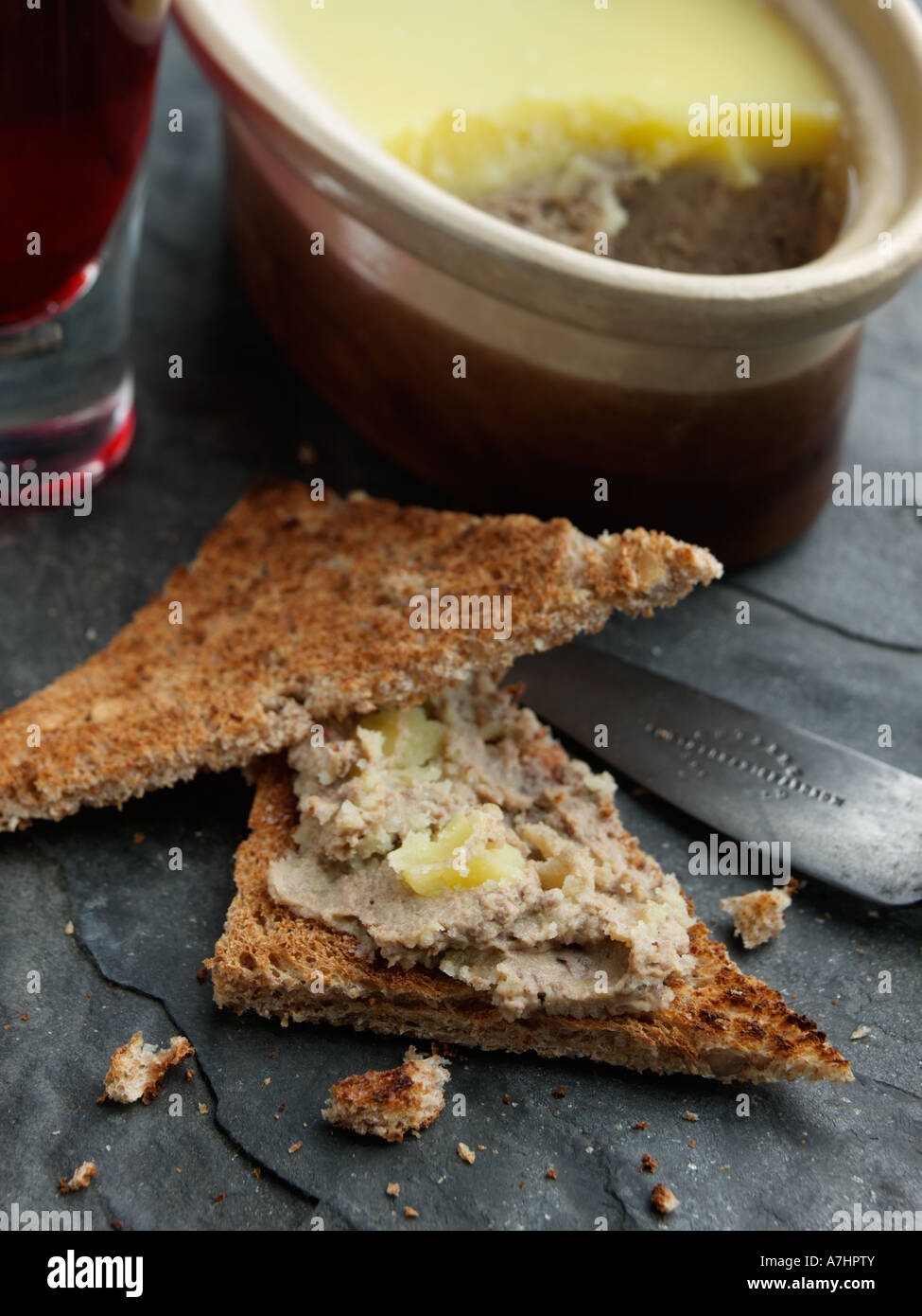A dish of chicken liver pate with toast and wine editorial food Stock