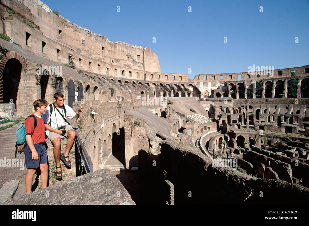 Two Male Students inside Coliseum in Rome ancient history Caucasian portrait landmark day outdoors casual clothes Stock Photo