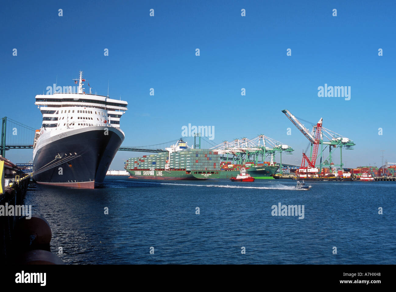 The Queen Mary 2 docked at berth 87 in the San Pedro harbor, Los Angeles, California, as a China Shipping container ship passes Stock Photo