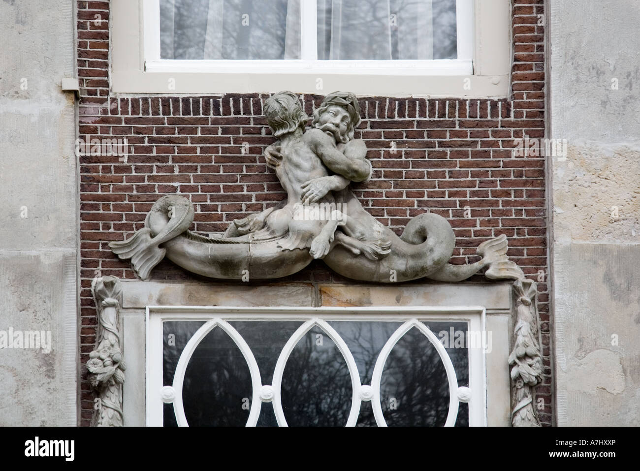 Sculpture of a merman and a mermaid above the entrance of a house in Dordrecht, Holland Stock Photo