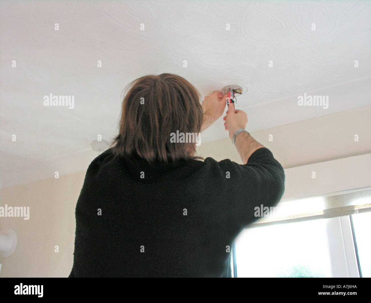 electrician repairing wiring in a light fitting Stock Photo - Alamy